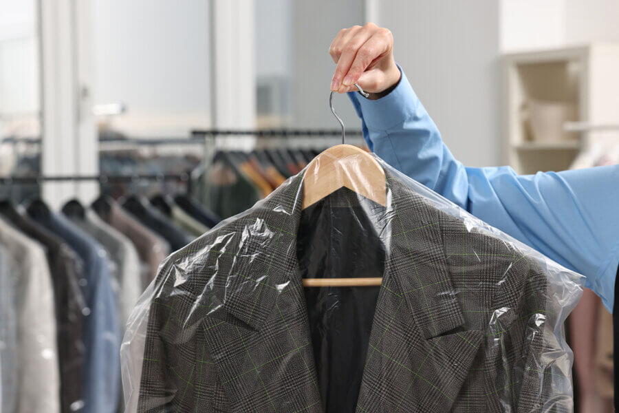 worker holding dry cleaned suit